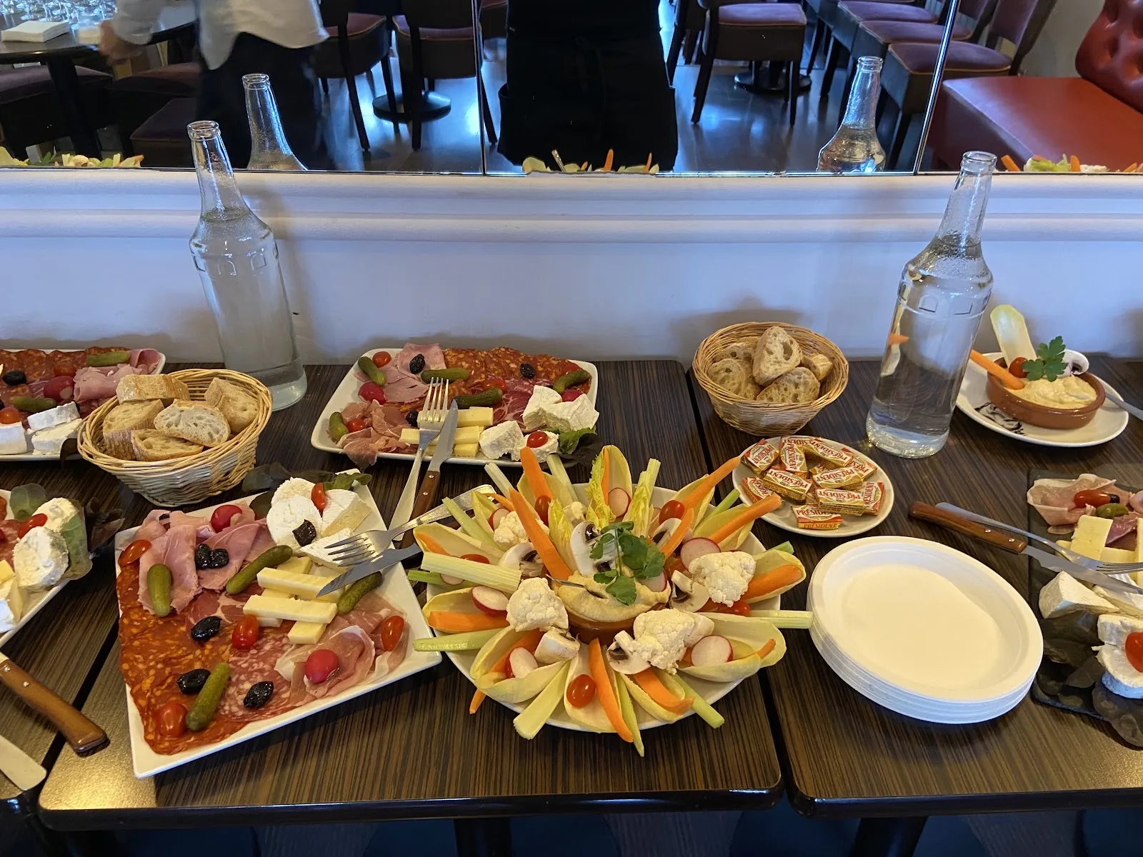 Planches de charcuterie, fromages et légumes croquants dressées sur la grande table